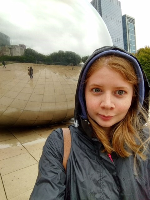 Selfie of a girl in a hood in front of a reflective background