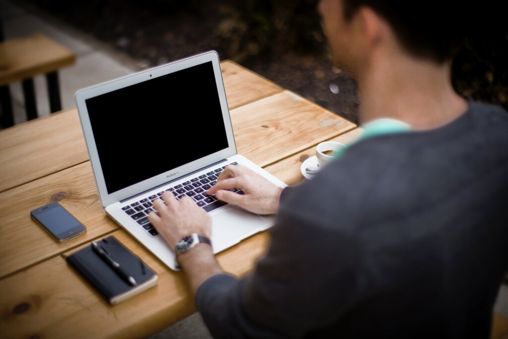 Adult using laptop on desk